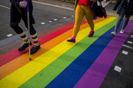 People walking on rainbow road crossing